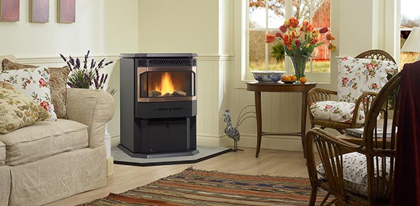 Greenfire GF55 Pellet Stove in corner of den with chairs and windows overlooking barn.